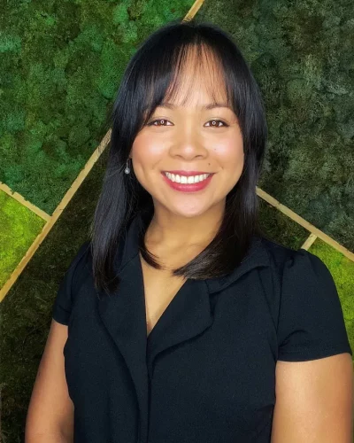 Woman standing in front of green moss background